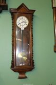 A wall clock with glass fronted case, Roman numerals with seconds dial, with pendulum but no key.