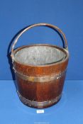 A brass banded wooden coal bucket with liner, 12'' diameter x 11'' tall.