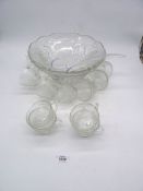 A glass Punch Bowl having grape vine design with 12 glasses and a ladle.