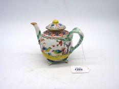 An unusual antique richly decorated teapot and cover with mask decoration,