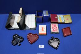 A box containing playing cards and four suit shaped ashtrays.