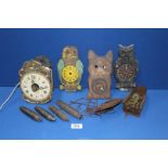 A collection of wobble eye clock parts, plus a small wooden clock.