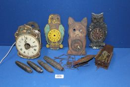 A collection of wobble eye clock parts, plus a small wooden clock.