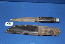 A Navy fighting knife with leather sheath.