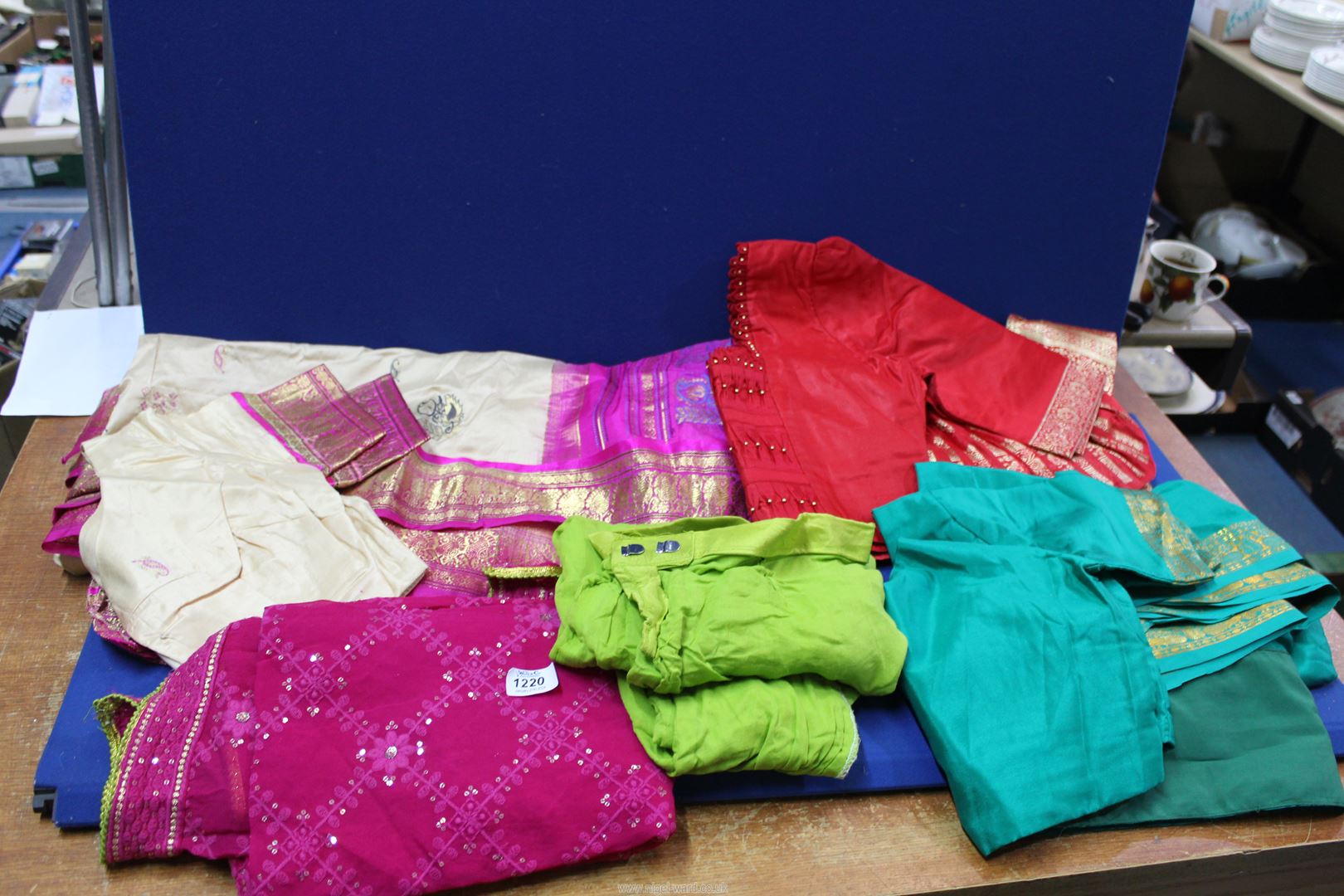 A quantity of saris, coordinating tops, etc., red with gold thread and pink with sequins, etc.