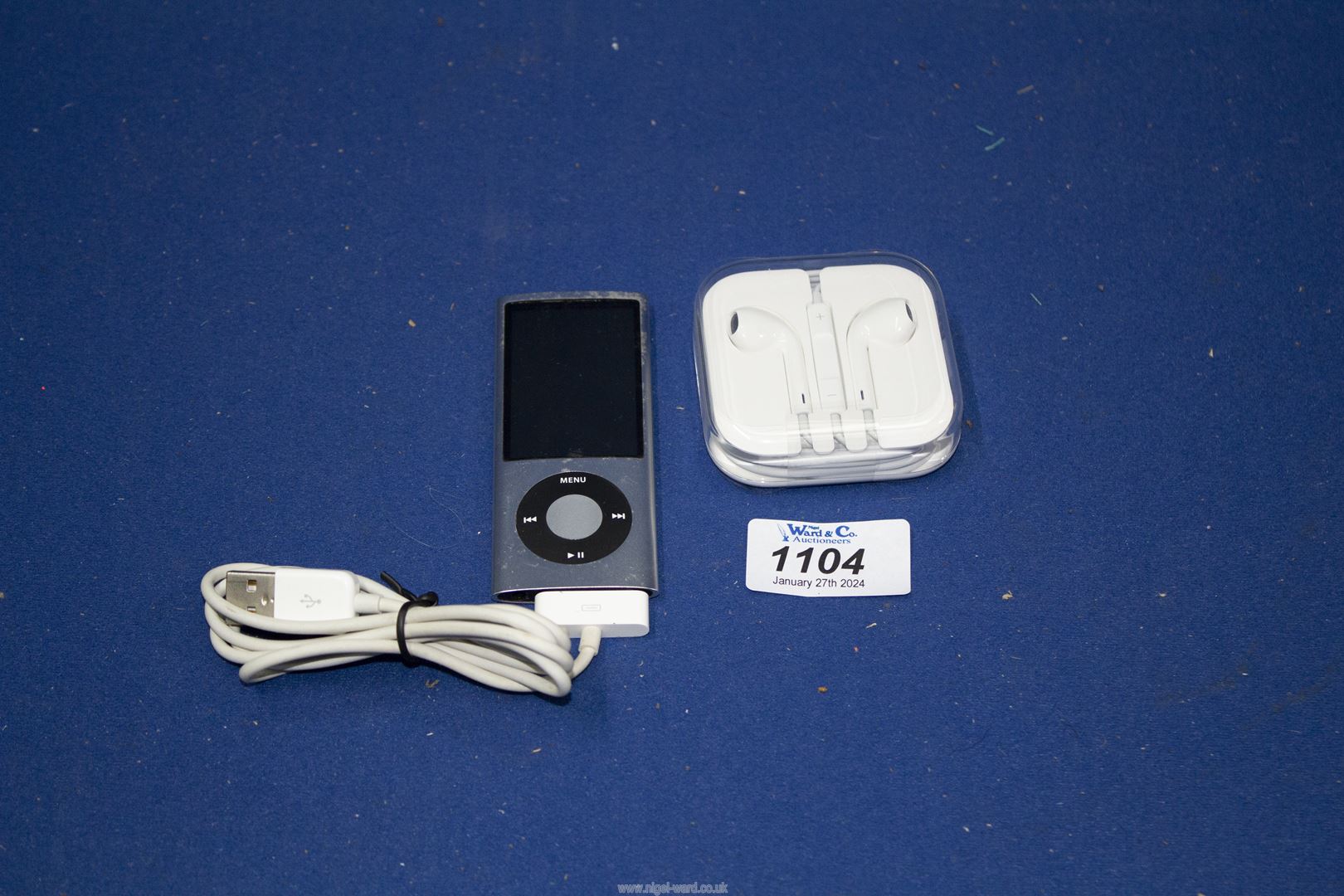 An Apple iPod Nano (5th Gen/Camera) 16GB with USB charging cable and sealed headphones.