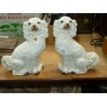 A pair of white mantle spaniels, one with crack to the leg.