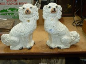 A pair of white mantle spaniels, one with crack to the leg.