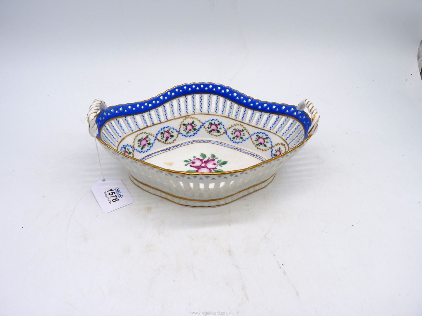 A quatrefoil shaped dish with open work sides, twisted handles and floral decoration.