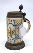 A German faience stein, 18th century, painted with flowers and with original pewter cover,