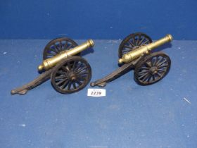 A small pair of brass cannon ornaments.