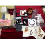 A box of costume jewellery including brooches, colourful beaded bracelet, leather bangles etc.