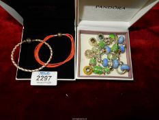 Three Pandora bracelets: one of braided leather, one of orange multi-strand fabric, green beads,