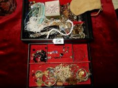 A black jewellery box and contents to include brooches, earrings, necklaces, etc.