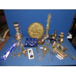 A quantity of mixed metals including cutlery, bell, candlestick, airplane, trivet etc.