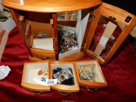 A wooden jewellery box with costume jewellery.