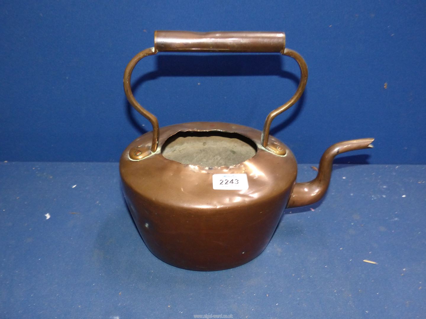 A copper kettle, damaged.