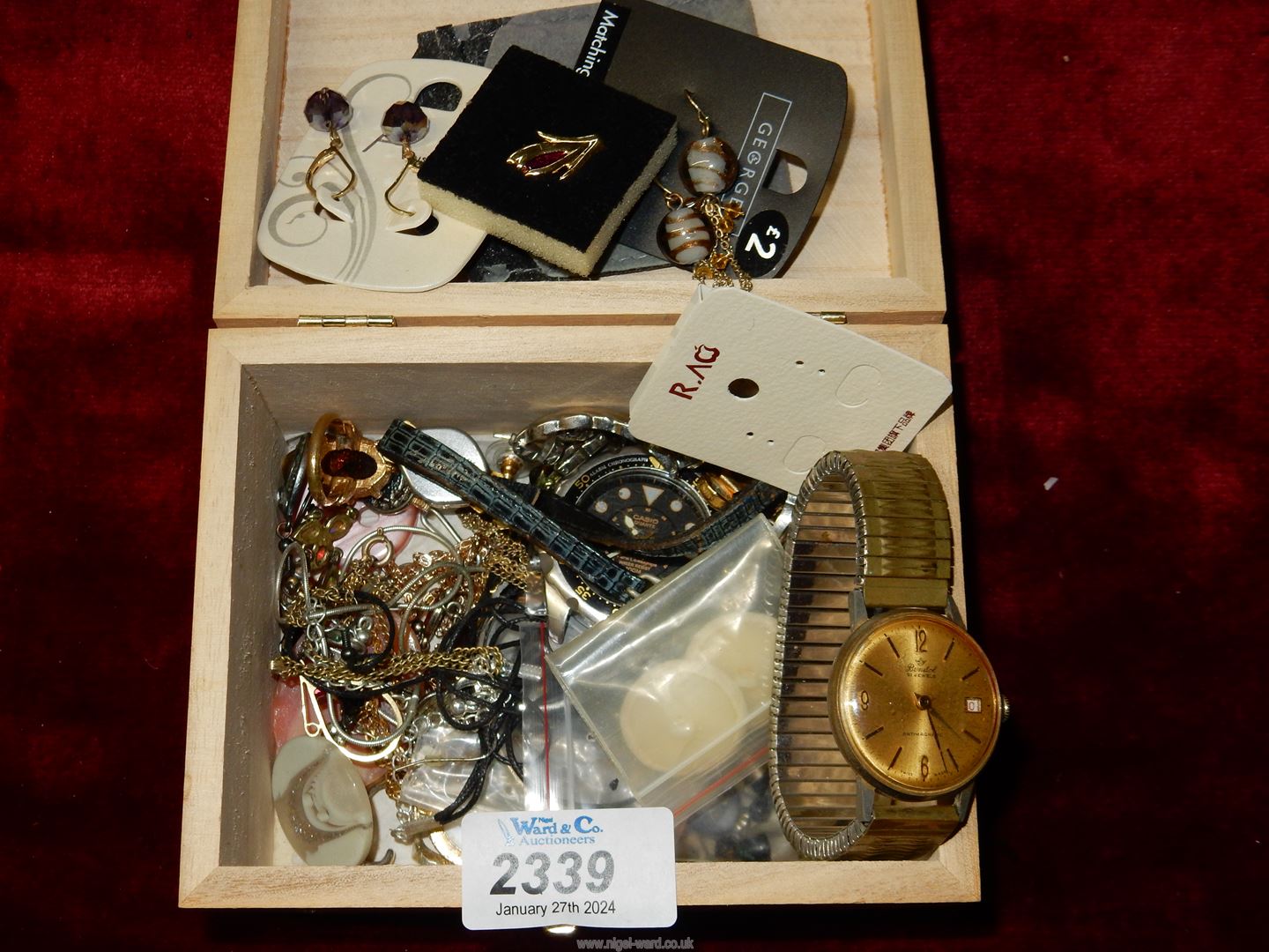 A wooden box of costume jewellery.