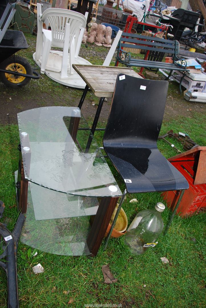 A metal based wooden topped table, T.V. stand, terracotta pots and black chair.