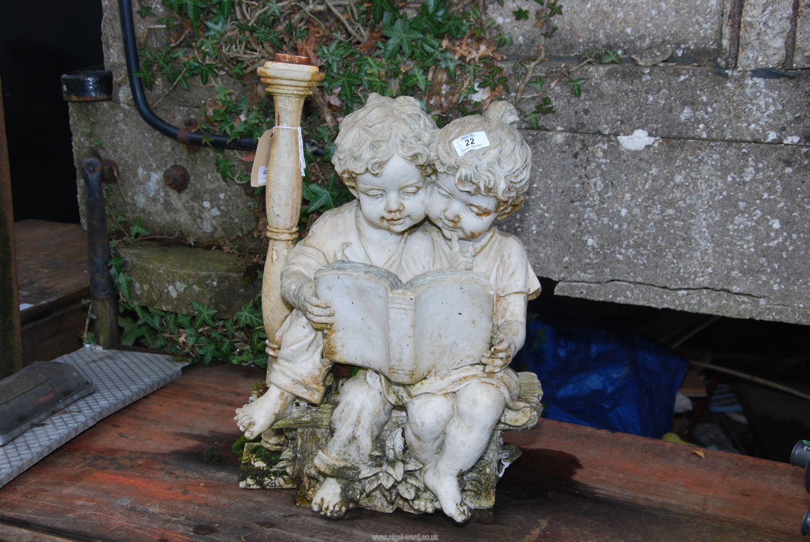 A figure of pair of children reading a book.