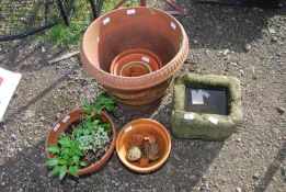 A stone planter 12" x 10 1/2" x 8" high, and miscellaneous terracotta pots.