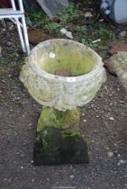 A small concrete lion and a circular planter.