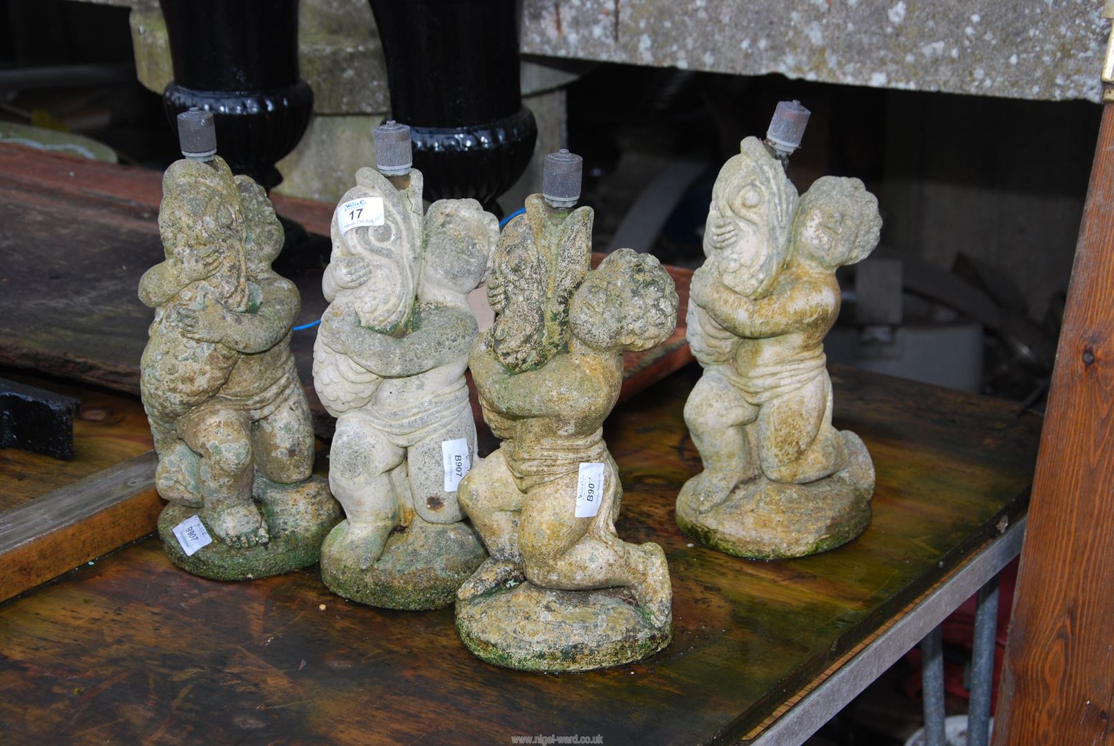 Four concrete water features of boys holding fish, 13'' high.