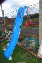 A blue slide and a swing seat with rope.