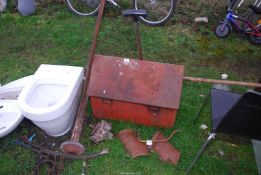 A metal tool box, hydraulic pump, rake and a fork.