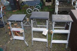 Three fold-up stepping stools.