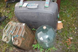 Two Jerry cans, a glass carbuoy, a Baleno case on wheels.