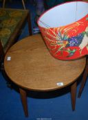A circular oak occasional table and a colourful lamp shade.