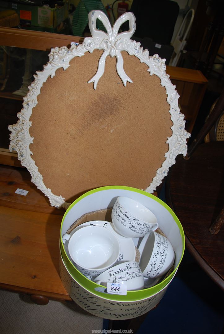 Four large cups and saucers and a mirror frame