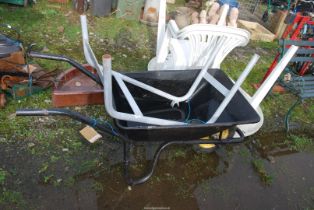 A Metal wheelbarrow and a concrete mixer stand.