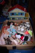 A dolls house and a box of soft toys.