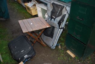 Fold-up table, wheeled suitcase and fishing chair.