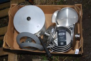 A box of graduated saucepans, aluminum pans, etc.