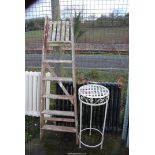 A six rung wooden step ladder and an aluminium plant stand.