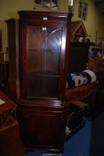 A glazed corner cupboard with key, 71'' high x 26'' wide.