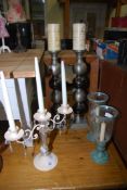 A candelabra and two pairs of candlesticks.