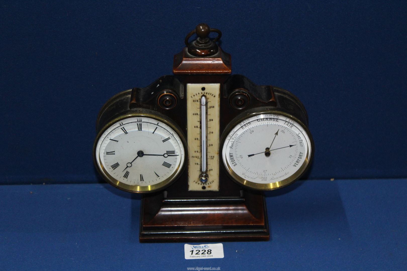 A combination barometer/ thermometer desk clock with key, 9" tall.
