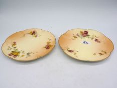 A pair of early 1900's Royal Worcester plates with wavy rims and decorated with pink and yellow