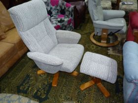A virtually as new flecked grey/white upholstered swivel Armchair and matching footstool.