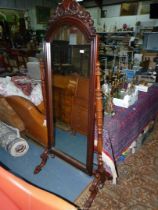 An elegant Mahogany framed swing action Robing/Cheval Mirror standing on turned pillar with scroll