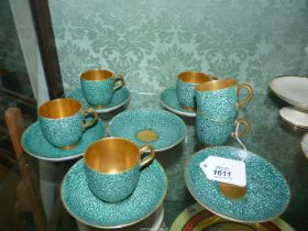 Six Royal Worcester coffee cups and saucers decorated in a blue/green pebble pattern having gilt