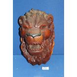 A heavy carved wall figure of a lion's head, 12" tall.