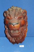 A heavy carved wall figure of a lion's head, 12" tall.