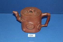 A Chinese terracotta Teapot having blossom relief, 5 1/2'' tall, lid chipped.