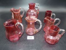 Seven Cranberry glass jugs (largest 5 1/2" tall), some with sharp pontils.