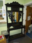 A dark Oak profusely carved Hallstand, the bevelled mirror flanked by mirrored dragon like beasts,